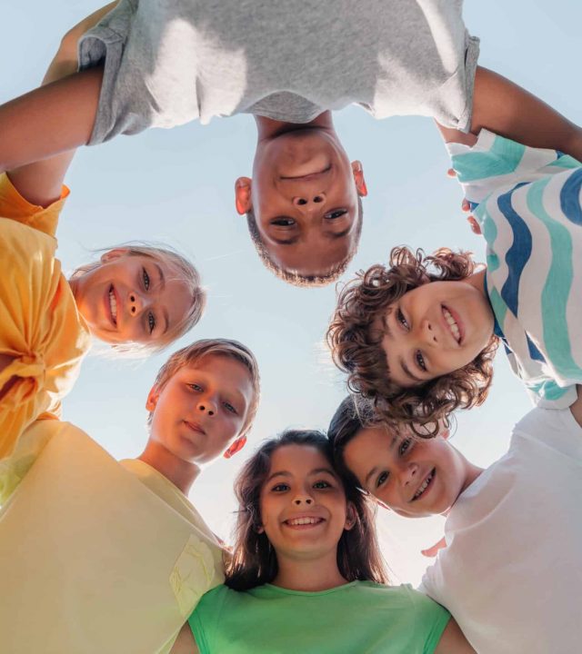 bottom view of positive multicultural children looking at camera